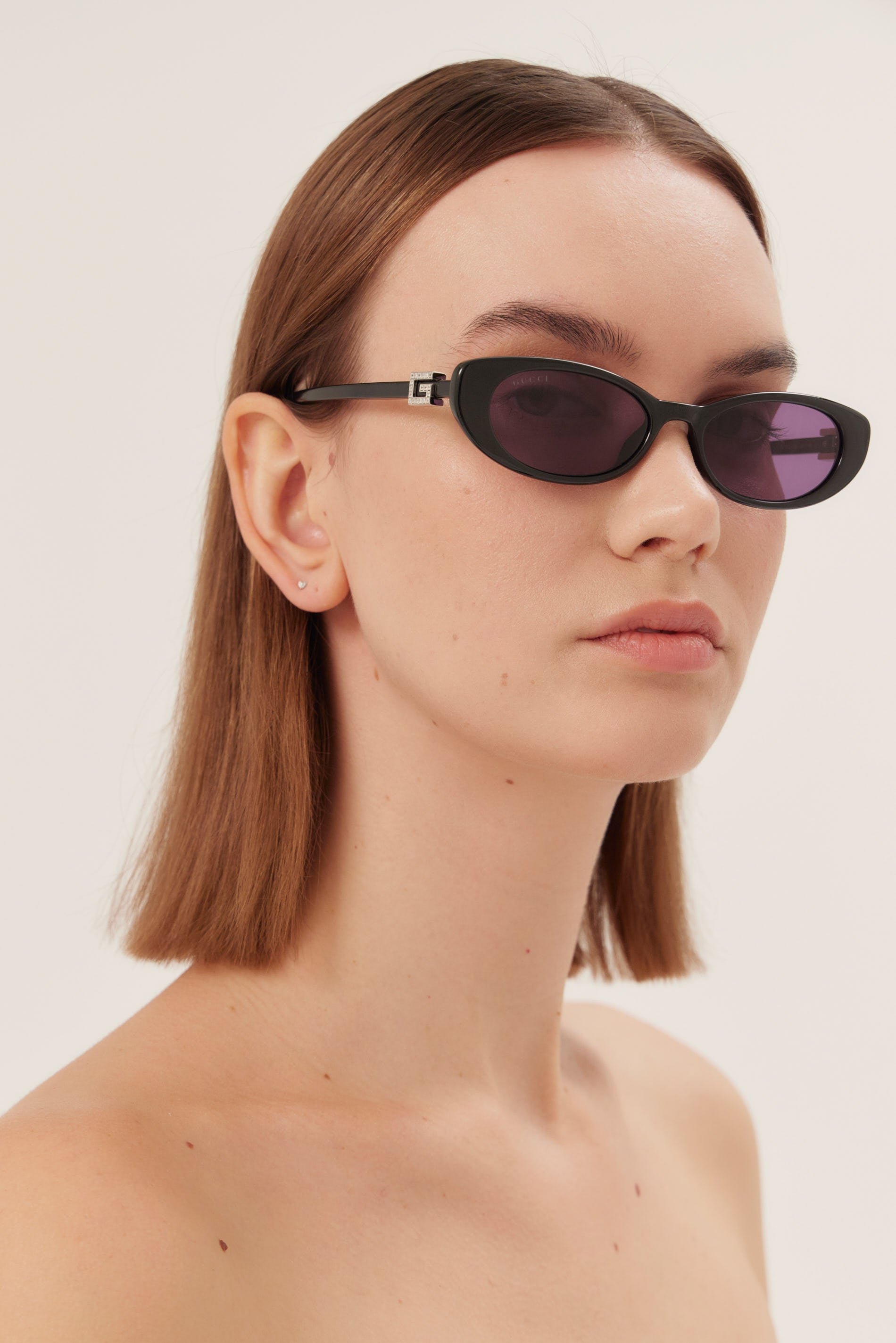 Oval cat-eye black Gucci sunglasses with bedded logo